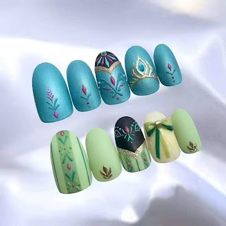Short teal and mint nails with leaf motifs, ornamental pattern details, and a small green bow